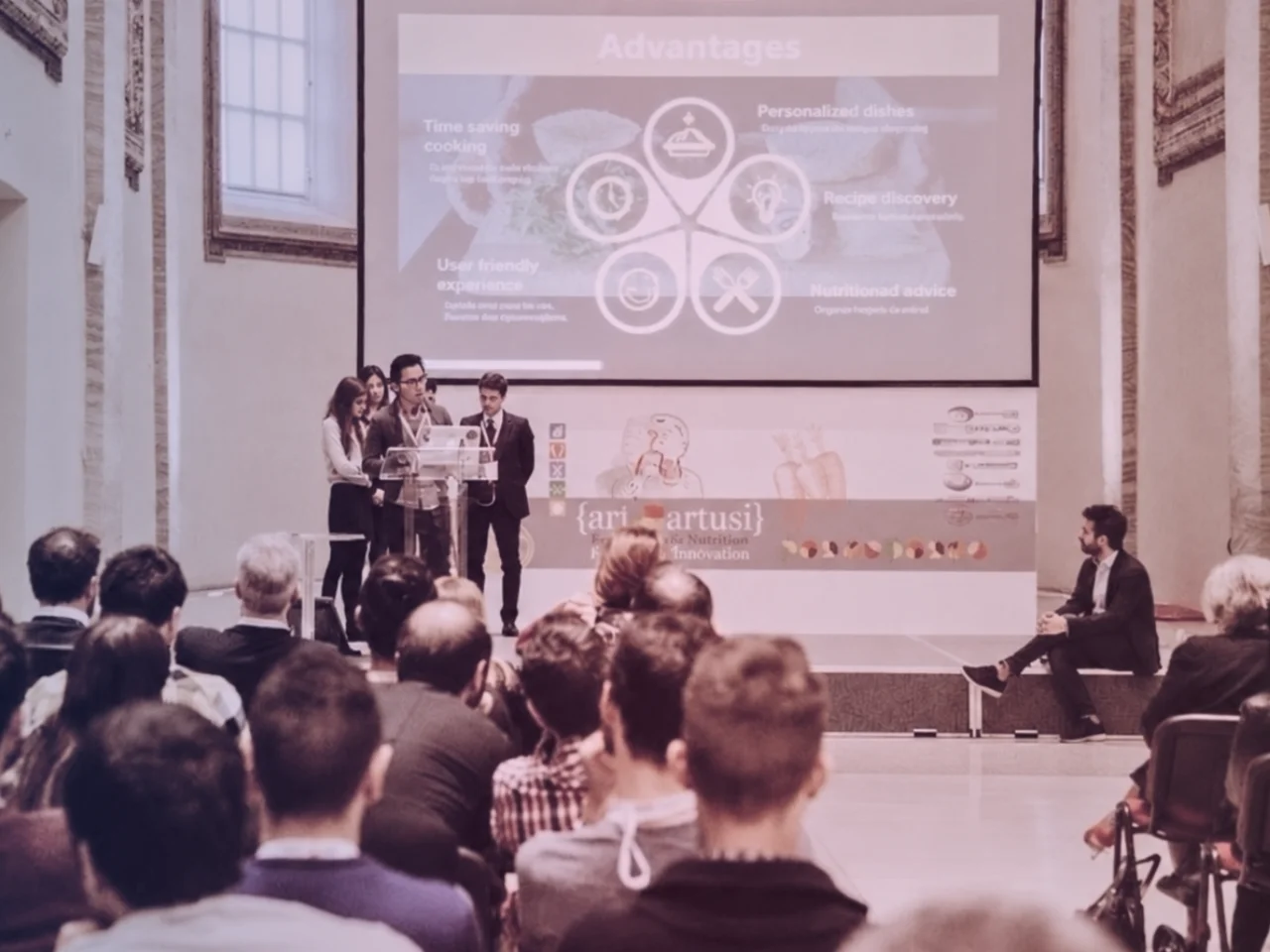 Rey presenting on stage at an event